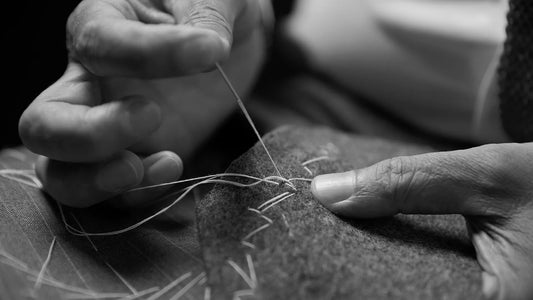 a close up with hands of an woman sewing a hat