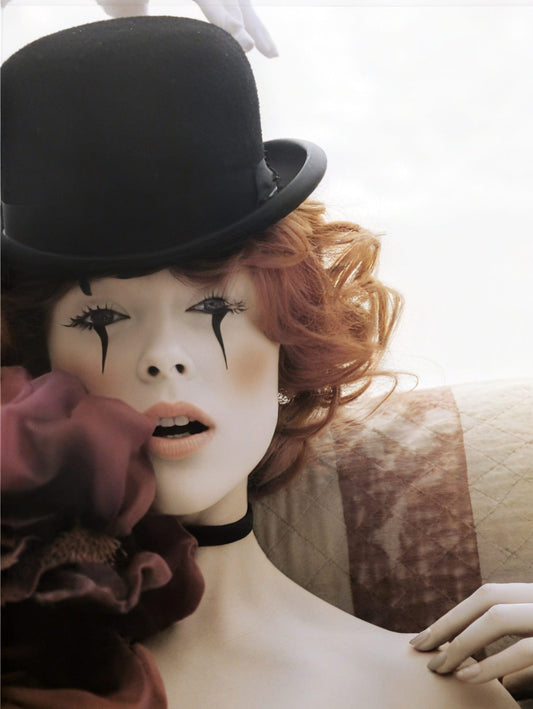 woman with clown make up wearing a black hat